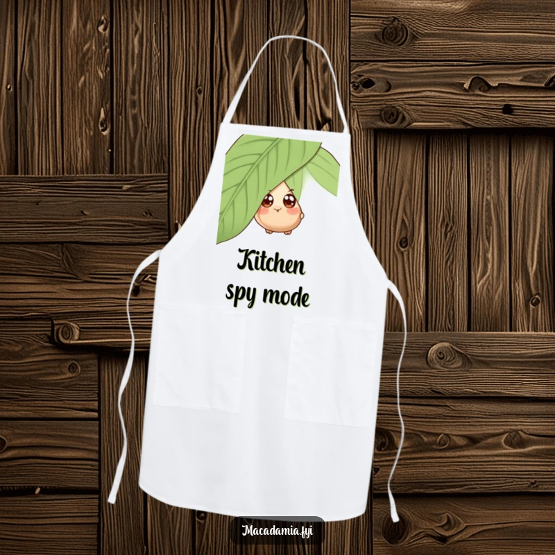 Funny apron with a wide-eyed macadamia nut character playfully peeking from behind a giant leaf, ready for kitchen fun.