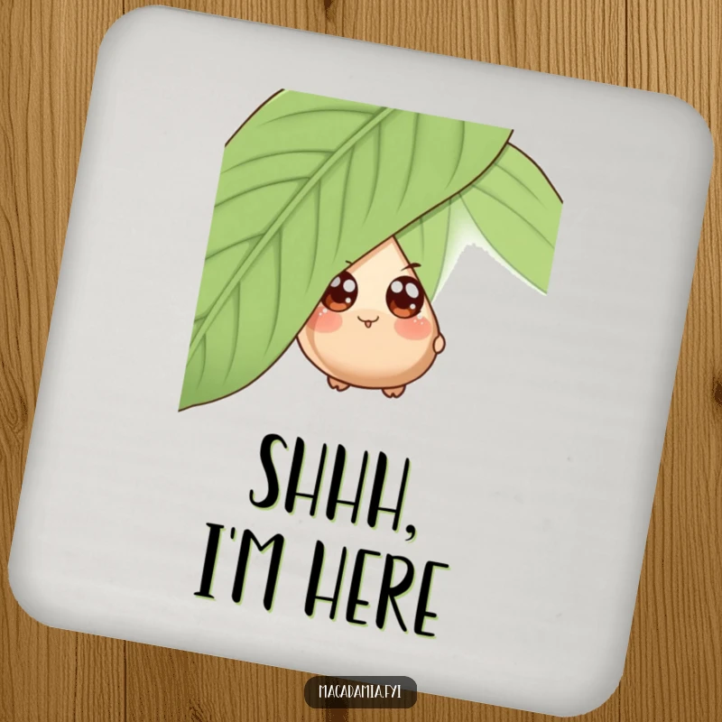 Funny drink coaster with a wide-eyed macadamia nut character playfully peeking from behind a giant leaf, adding charm.