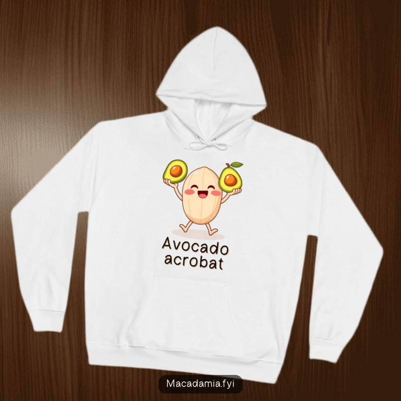Funny hoodie featuring a smiling macadamia nut character on legs happily juggling three shiny avocados, bringing warmth and laughter.